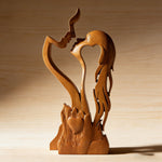 Light-finish wooden couple sculpture showing the profiles, heart and carved detail